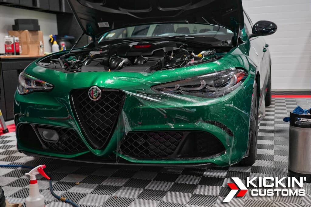 Alfa Romeo Giulia Quadrifoglio undergoing paint protection film installation inside Kickin’ Customs, serving clients from Quincy, MA